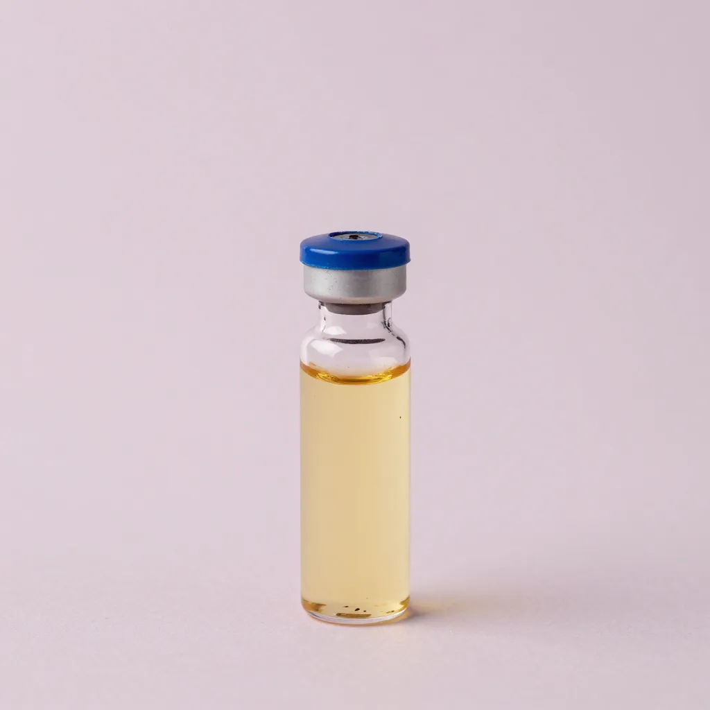 A tiny sample vial of blueberry seed oil on a pale background